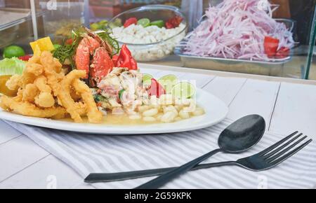Typische peruanische Küche, Tintenfisch-Ceviche, Garnelen, Krabben und weißer Fisch mit lila Zwiebeln und einer guten Tigermilch. Stockfoto