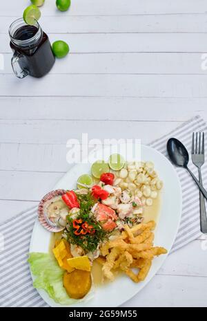 Typische peruanische Küche, Tintenfisch-Ceviche, Garnelen, Krabben und weißer Fisch mit lila Zwiebeln und einer guten Tigermilch. Stockfoto