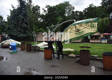 Lviv, Ukraine. Juni 2021. Männer heben einen Regenschirm, der nach einem starken Gewitter vom Wind in Lviv heruntergeblasen wird. (Foto von Pavlo Palamarchuk/SOPA Images/Sipa USA) Quelle: SIPA USA/Alamy Live News Stockfoto