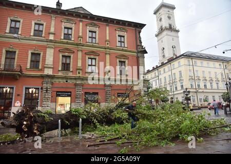 Lviv, Ukraine. Juni 2021. Arbeiter demontieren einen umgestürzten Baum durch ein starkes Gewitter in Lviv in der Nähe des Rynok-Platzes. (Foto von Pavlo Palamarchuk/SOPA Images/Sipa USA) Quelle: SIPA USA/Alamy Live News Stockfoto