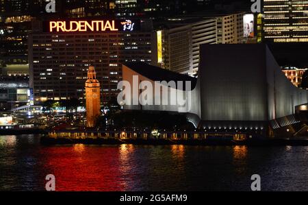 Blick auf die Uferpromenade von TST mit dem Gebäude des Kulturzentrums und dem ehemaligen Eisenbahnturmturm Kowloon-Canton. Kowloon, Hongkong. Stockfoto