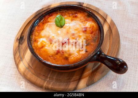 Gnocchi alla Sorrentina, italienische Kartoffelknödel in Tomatensauce, mit Mozzarella-Käse in einer Terrakotta-Schale geriebt Stockfoto