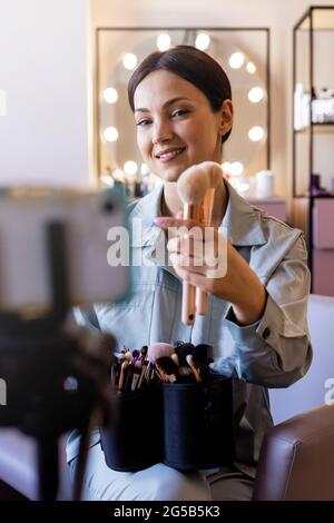 Glückliche weibliche Schönheit blogger Aufnahme vlog Beratung Wahl Pinsel für die Anwendung von Kosmetik Stockfoto