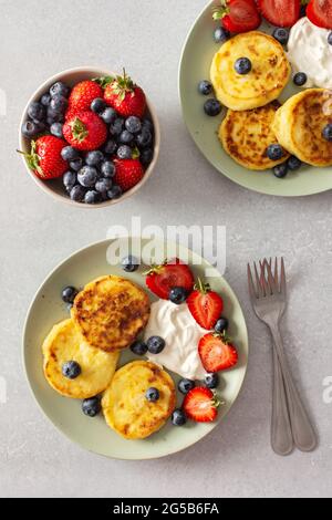Quark Pfannkuchen mit Erdbeeren, Heidelbeeren und saurer Creme und frischen Beeren, leckeres Frühstück, Blick von oben Stockfoto
