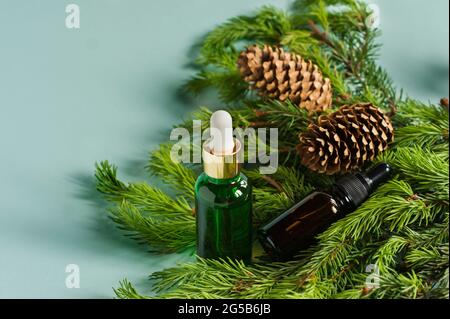 Ätherisches Öl aus Kiefer und Fichte in kleinen Glasflaschen auf blauem Hintergrund Stockfoto