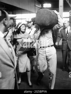 ELVIS PRESLEY, der eine Duffle Bag hält, erhält am 22. September 1958 im Brooklyn Army Terminal in New York ein Abschiedsgeschenk von LILLIAN PORTNOY aus Beverly Hills California, bevor er zum Militärdienst nach Bremerhaven fährt Stockfoto