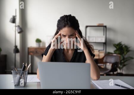 Unwohl Frau leiden unter Kopfschmerzen am Computer arbeiten Stockfoto