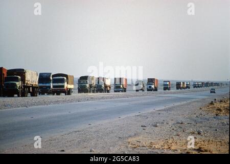 Auf der Straße, die aus Saudi-Arabien kommt, kommt ein LKW-Konvoi mit Waren in der Stadt Doha, Bundesstaat Katar. Diafild aus dem Jahr 1991 aufgenommen und gescannt. Stockfoto