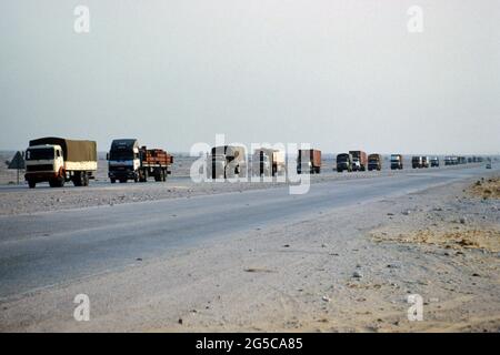 Auf der Straße, die aus Saudi-Arabien kommt, kommt ein LKW-Konvoi mit Waren in der Stadt Doha, Bundesstaat Katar. Diafild aus dem Jahr 1991 aufgenommen und gescannt. Stockfoto