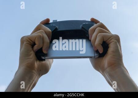 Person, die eine drahtlose Gadget-Fernbedienung mit Joystick und Antennen hält Stockfoto