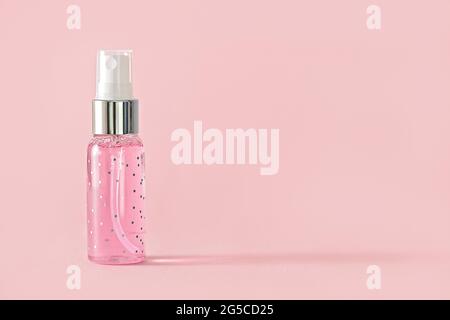 Kleine transparente pinke Flasche mit Spray auf rosa Hintergrund, mit Kopierraum Stockfoto