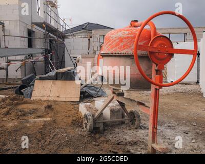 Roter manueller Zementmischer auf einer Baustelle Stockfoto