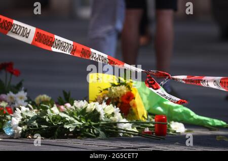 Würzburg, Deutschland. Juni 2021. 26. Juni 2021, Bayern, Würzburg: Kerzen und Blumen liegen vor einem geschlossenen und abgesperrten Laden in der Innenstadt. In Würzburg griff ein Mann am Vortag zufällig Menschen mit einem Messer an. Drei Menschen starben, mindestens fünf wurden schwer verletzt. Foto: Karl-Josef Hildenbrand/dpa Quelle: dpa picture Alliance/Alamy Live News Stockfoto