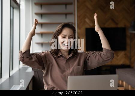 Überglücklich junge Geschäftsfrau feiert Online-Erfolg. Stockfoto