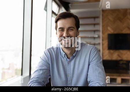 Lächelnder, aufrichtiger junger Mann, der die Kamera anschaut. Stockfoto