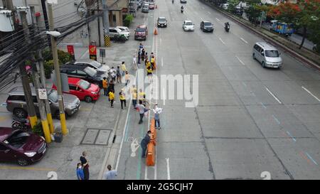 Quezon City, Philippinen. Juni 2021. Menschen winken mit gelben Bändern und halten die philippinische Flagge, während die Begräbnismotorkade des ehemaligen Präs Noynoy Aquino durch C5 in Quezon City fuhr. (Foto von Sherbien Dacalanio/Pacific Press) Quelle: Pacific Press Media Production Corp./Alamy Live News Stockfoto