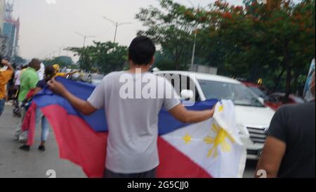 Quezon City, Philippinen. Januar 2018. Menschen winken mit gelben Bändern und halten die philippinische Flagge, während die Begräbnismotorkade des ehemaligen Präs Noynoy Aquino durch C5 in Quezon City fuhr. (Foto von Sherbien Dacalanio/Pacific Press) Quelle: Pacific Press Media Production Corp./Alamy Live News Stockfoto