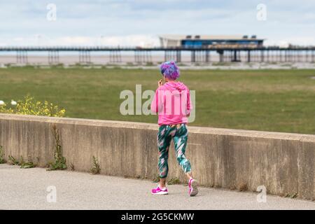 Southport, Großbritannien. Juni 2021. Helle Farben an einem langweiligen Tag, an dem Anwohner am frühen Morgen an der Strandpromenade des Resorts trainieren. Quelle: MediaWorldLimages/Alamy Live News Stockfoto