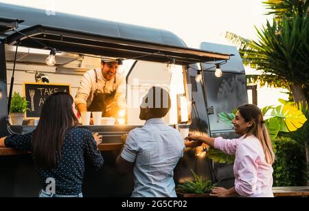 Junge Leute kaufen Essen von Street Food Truck - modernes Geschäft und Take-away-Konzept Stockfoto