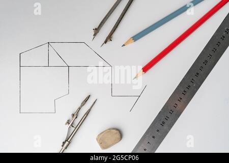 Zeichnen eines Plans auf einer farbigen Oberfläche mit dem Stift, Lineal, Kompass und anderen Werkzeugen, Geometrieformen Stockfoto