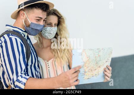 Reise junges Paar mit Stadtplan während einer Reise, während sie Gesichtsmaske trägt, um Corona-Virus zu verhindern Stockfoto