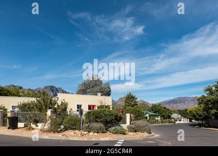 FRANSCHHOEK, SÜDAFRIKA - 12. APRIL 2021: Eine Straßenszene mit Häusern in Franschhoek in der Provinz Westkap. Ein Papierkorb ist sichtbar Stockfoto