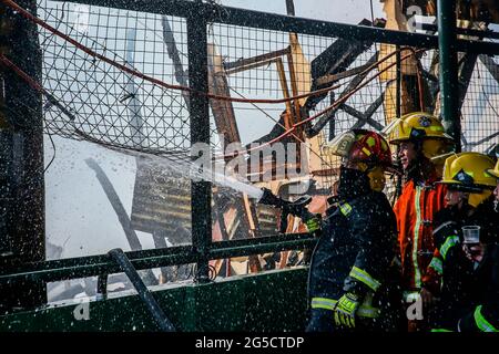 Quezon City. Juni 2021. Feuerwehrleute versuchen, am 26. Juni 2021 ein Feuer in einem Wohngebiet in Quezon City auf den Philippinen zu löschen. Quelle: Rouelle Umali/Xinhua/Alamy Live News Stockfoto