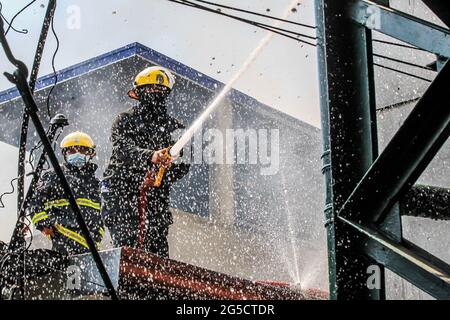 Quezon City. Juni 2021. Feuerwehrleute versuchen, am 26. Juni 2021 ein Feuer in einem Wohngebiet in Quezon City auf den Philippinen zu löschen. Quelle: Rouelle Umali/Xinhua/Alamy Live News Stockfoto