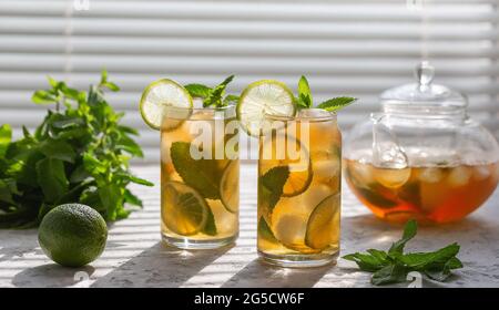 Eistee mit Minze und Limette vereist. Kühlender Sommerdrink. Stockfoto
