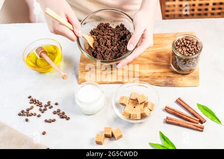 Frau, die Zutaten für die Zubereitung von Kaffee-Peeling oder Maske für die Hautbehandlung mischt Stockfoto