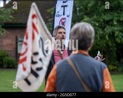 LICHFIELD. VEREINIGTES KÖNIGREICH. JUNI 2021. HS2 Rebellion Stop die HS2-Rallye im Beacon Park, Lichfield, markiert den Beginn einer 8-tägigen Wanderung nach Wigan, um die Aufmerksamkeit auf die Stop HS2-Kampagne zu lenken. Der Aktivist Dr. Larch Maxey, der nach seiner Verhaftung wegen Demonstrationen und Tunnels unter dem Londoner Euston HS2-Gelände immer noch ein Polizeiknöchelchen trägt, spricht zu einer Menge von etwa 60 Personen, die sich zur Unterstützung versammelten. Kredit: Richard Grange / Alamy Live Nachrichten Stockfoto