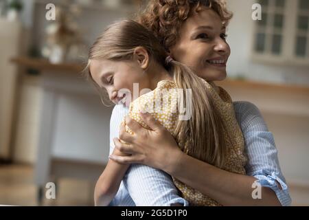 Glücklich ziemlich wenig Vorschule 6s Kind Mädchen kuscheln liebevolle Mutter. Stockfoto