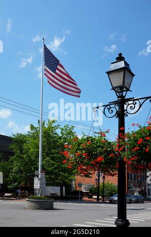 COOPERSTOWN, NEW YORK - 21. JUNI 2021: Flagge und Laternenpfosten an der Kreuzung von Main Street und Pioneer Street in der Upstate Town und Heimat der Nati Stockfoto