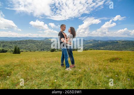 Junges Paar umarmt auf erstaunliche Berglandschaft Hintergrund. Stockfoto