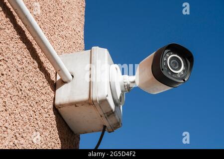 An der Außenwand eines Gebäudes installierte Sicherheits- oder Überwachungskamera. Konzept Sicherheit, Fernüberwachung, Überwachung. Stockfoto