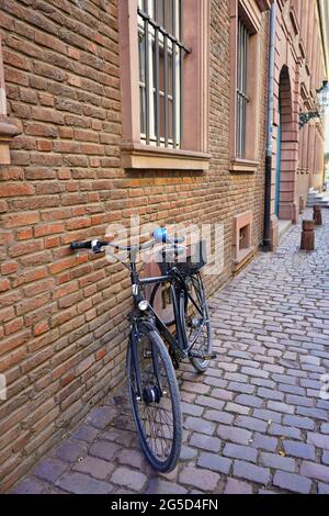 Typische Seitenstraße in der historischen Düsseldorfer Altstadt mit Backsteingebäude, Vintage-Fahrrad und Pflastersteinpflaster. Stockfoto