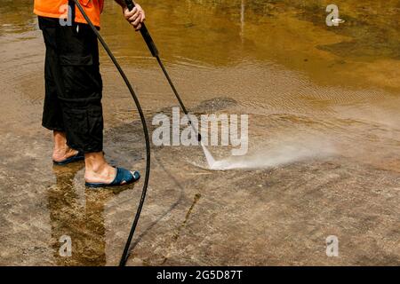 Vorbeugende Reinigung von Stadtbrunnen im Sommer. Arbeiter säubern den angesammelten Schmutz. Stockfoto