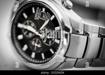 Monochromes Schwarz-Weiß-Nahaufnahme eines Citizen Eco Drive solarbetriebenen Titan-Metall-Männerarmbanduhrs mit Zeigern für Uhrzeiger und Armband Stockfoto