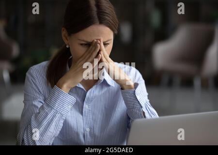 Frustrierte, unglückliche junge Frau, die E-Mails mit schlechten Nachrichten las. Stockfoto