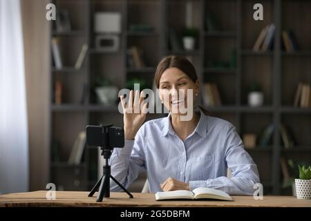 Lächelnd attraktive junge Frau, die Bildungsvideos aufzeichnet. Stockfoto