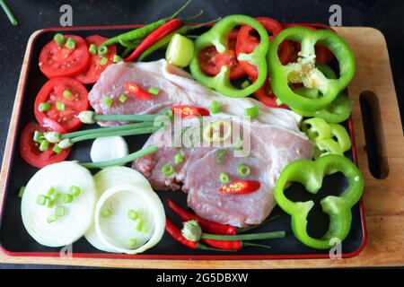Zutaten für ein festliches Gericht, Fleisch mit Gemüse und Gewürzen, Tomaten, Zwiebeln, roten und grünen Paprika, Ingwer, DillZutaten für ein festliches Gericht, Stockfoto