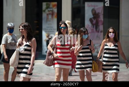 Malaga, Spanien. Juni 2021. Eine Gruppe von Frauen, die Gesichtsmasken tragen und andere ohne Gesichtsmaske, werden auf dem Platz Plaza de la Constitucion zu Fuß beobachtet.ab dem 26. Juni erlaubt die spanische Regierung Spaniern, an Orten im Freien ohne obligatorische Gesichtsmasken zu gehen, solange die Menschen die soziale Distanz halten. Kredit: SOPA Images Limited/Alamy Live Nachrichten Stockfoto