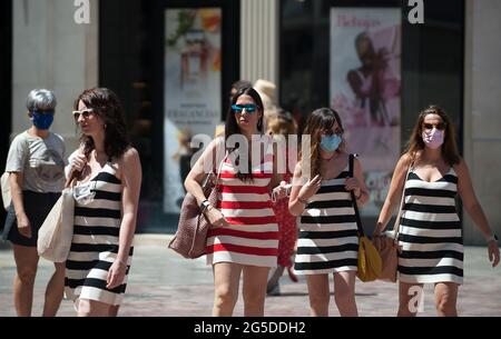 Malaga, Spanien. Juni 2021. Eine Gruppe von Frauen, die Gesichtsmasken tragen und andere ohne Gesichtsmaske, werden auf dem Platz Plaza de la Constitucion zu Fuß beobachtet.ab dem 26. Juni erlaubt die spanische Regierung Spaniern, an Orten im Freien ohne obligatorische Gesichtsmasken zu gehen, solange die Menschen die soziale Distanz halten. (Foto von Jesus Merida/SOPA Images/Sipa USA) Quelle: SIPA USA/Alamy Live News Stockfoto