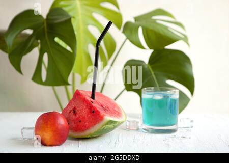 Wassermelone und blauer curacao Cocktail auf dem weißen Brett. Köstliches Cocktail-Getränk mit frischen Früchten mit Pfirsich und Eis. Wassermelone blau Sommer ai Stockfoto