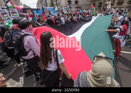 London, Großbritannien. Juni 2021. Menschen mit riesiger palästinensischer Flagge. Mehr als fünftausend nahmen an der Volksversammlung teil, die durch London gegen die Misserfolge der Tory-Regierung während der Pandemie marschierte, zu spät agierte, Verträge an Kumpanen verteilte und wichtige Arbeiter nicht für ihre Opfer belohnte. Sie forderten eine „neue Normalität“ mit einem Ende der NHS-Privatisierung, menschenwürdigem Wohnungsbau, echten Maßnahmen gegen den Klimawandel, menschenwürdigem Wohnungsbau, einem Ende unfairer Beschäftigungspraktiken und der Plünderung korrupter Politiker. Peter Marshall/Alamy Live News Stockfoto