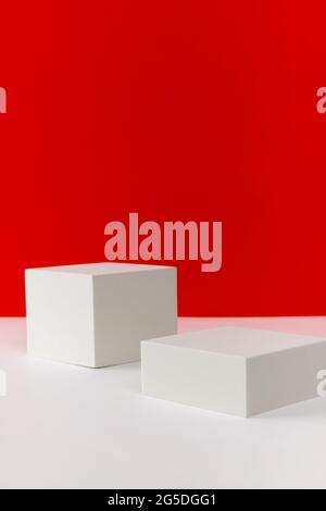 Podium auf rot-weißem, kreativem Hintergrund. Modellvorlage für das Produkt Stockfoto