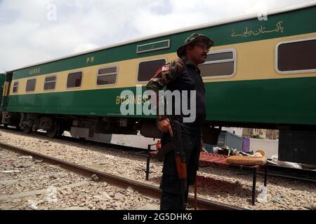 Sicherheitsbeamter ist sehr wachsam, um Untowards-Vorfälle während der Anti-Aschroatment-Fahrt unter der Aufsicht der Pakistan Railways in der Swat Char Bagh Railway Colony in Karachi am Samstag, 26. Juni 2021 zu vermeiden. Stockfoto