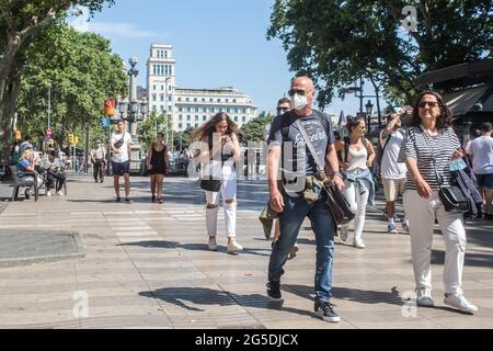 Barcelona, Katalonien, Spanien. Juni 2021. Mann mit Schutzmaske und Frau ohne Schutzmaske sind in Las Ramblas in Barcelona zu sehen.Barcelona am ersten Tag ohne die obligatorische Verwendung einer Schutzmaske in Spanien. Der Präsident der spanischen Regierung, Pedro Sanchez, kündigte am 18. Juni an, dass die Verwendung von Schutzmasken in Außenumgebungen ab Juni 26 nicht mehr obligatorisch sein wird, nachdem sie von einem außerordentlichen Ministerrat genehmigt wurde. Quelle: Thiago Prudencio/DAX/ZUMA Wire/Alamy Live News Stockfoto