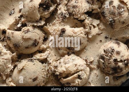 Muster aus cremigem Eis mit Cookies in Kugeln aus Schaufel. Dessert ohne Zucker für sauberes Essen. Stockfoto