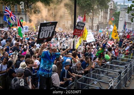 London, Großbritannien. Juni 2021. Demonstranten, die Plakate halten, marschieren während der Demonstration in Whitehall hinunter. Anti-Lockdown-Gruppen schließen sich zusammen, um sich für die Freiheit zu vereinen. Menschen, die gegen die Sperren protestierten, kamen zusammen, um ihre Bedenken hinsichtlich der staatlichen Gesetzgebung zum Thema Impfung und Reisefreiheit zu äußern. Kredit: SOPA Images Limited/Alamy Live Nachrichten Stockfoto